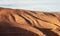Panorama of hills with regular brown soil pattern in Tizi`n-Tinififft pass Ouaourmas Morocco, blue sky above