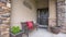 Panorama Home facade with bench welcome sign and potted plants on the porch