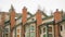 Panorama Homes with white wall sidings and red brick chimneys against cloudy sky