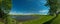 panorama, horizontal view of bay. Great blue lake and green field