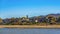 Panorama Houses amid lush foliage overlooking a lake with brown grasses on the shore