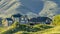 Panorama Houses at the base of a mountain under bright sky on a sunny day