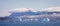 Panorama of icebergs in Prince Christian Sound against backdrop of mountains with low hanging cloud in Greenland