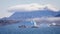 Panorama of icebergs in Prince Christian Sound against backdrop of mountains with low hanging cloud in Greenland