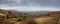 Panorama image of landscape in Burren area. West of Ireland. Beautiful mountains and green field and small road, Cloudy sky. Irish