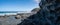 Panorama of intricate rock formations on ocean coastline.