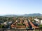 Panorama of the Italian town, view from the Leaning Tower of Pisa, brown roofs, mountains, sky