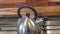 Panorama Kettle on the cooktop against wooden chopping board and tile backsplash