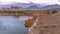 Panorama Lake with rocks lining the shore and an arched bridge over its shiny water