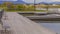 Panorama Lake with wooden deck and benches overlooking houses beyond the grassy shore