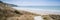 Panorama landscape across grassy sand dunes on beach