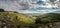 Panorama landscape with forested hills and rocks, cloudy sky