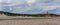 Panorama landscape of Happisburgh beach and lighthouse with tall sand dunes and cliffs