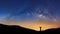 Panorama landscape with milky way, Night sky with stars and silhouette of a standing sporty man with raised up arms on high mount