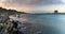 Panorama landscape with rocky shore at sunset and the Torrre de la Pelosa watchtower in northern Sardinia