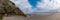 Panorama landscape view of Maghera Beach with the entrance to one of the caves in the rocks