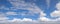 Panorama of large wispy cloud in blue sky.