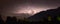 Panorama of a lightning in a thunderstorm at night over Italy, viewed from a scenic town in Slovenia