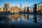 Panorama of lower Manhattan reflected in the water puddle on the walkway of Brooklyn Bridge park