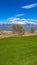 Panorama Lush green field in front of a lake with grassy shore viewed on a sunny day