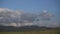 Panorama of many huge wind turbines on the horizon line with blue sky with clouds. Green technology concept. Industrial