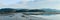 panorama of marshes with forests and mountains in the background at sunset