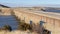 Panorama Massive bridge over a calm blue lake amid snow covered land in winter