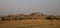 Panorama of Montana`s Terry Badlands Striped Mountains with Field of Dried Grass in Golden Light