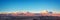 Panorama of Moon Valley in Atacama desert at sunset, snowy Andes mountain range in the background Chile