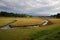 Panorama of a moorland in autumn in the grassy landscape with curved river with forest and mountains in the background