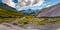 Panorama of a mountain stream, glacier and rocks