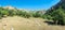 Panorama of a mountain valley in the summer afternoon in sunny weather.