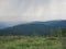 Panorama of mountains on a rainy day, silhouettes of mountain ranges in the haze on the horizon