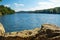 Panorama of a natural body of water with a rock in the foreground in a forest landscape. Brno Reservoir - Czech Republic