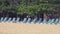 Panorama on a number of empty chaise lounges standing on sandy beach of the tropical resort