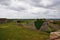 Panorama of the old fortress. The destroyed walls of the fortress and fields with green grass.