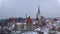 Panorama of the old town overlooking the Church of Oleviste St. Olaf in March snowfall. Tallinn, Estonia