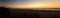 Panorama of the Oregon coast beach with a magnificent sunset and people taking a stroll