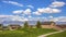 Panorama Pathway on a vast grassy terrain leading to the houses in front of a lake