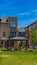 Panorama Patio on a lawn surrounded by townhouses with bright blue sky overhead