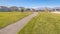 Panorama Paved footpath through a residential park near sunset