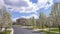 Panorama Paved road lined with white flowering trees on a scenic neighborhhod