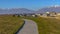 Panorama Paved road on a lush grassy hill overlooking beautiful houses on a sunny day