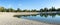 Panorama of a pebble beach on a lake in Bundek city park, Zagreb, Croatia