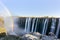 Panorama photo of Victoria Falls waterfall on Zambezi river in very high flow in late evening light with rising spray and