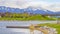 Panorama Picturesque lake scenery with wooden deck and rocks on the grassy shore