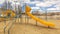 Panorama Playground with slides and swings under the blue sky filled with puffy clouds