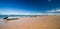 Panorama with pleasure boats on the beach with golden sand, blue sky