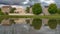 Panorama Pond with reflection of multi storey homes lush trees and cloud filled sky