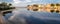 Panorama of Portocolom harbour with boats, traditional houses and calm sea with reflection, Mallorca, Spain